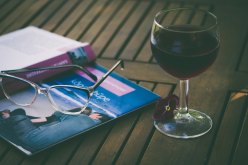 The Author Chronicles, glass of wine, glasses, open book open side down on table